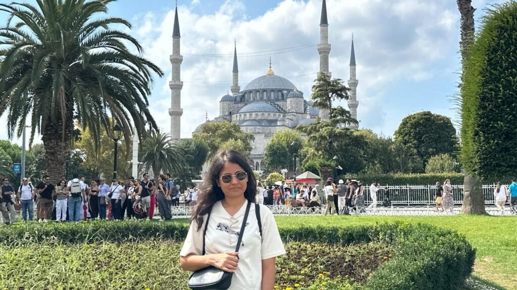 Sanju in the gardens of Sultanahmet with the Blue Mosque behind her