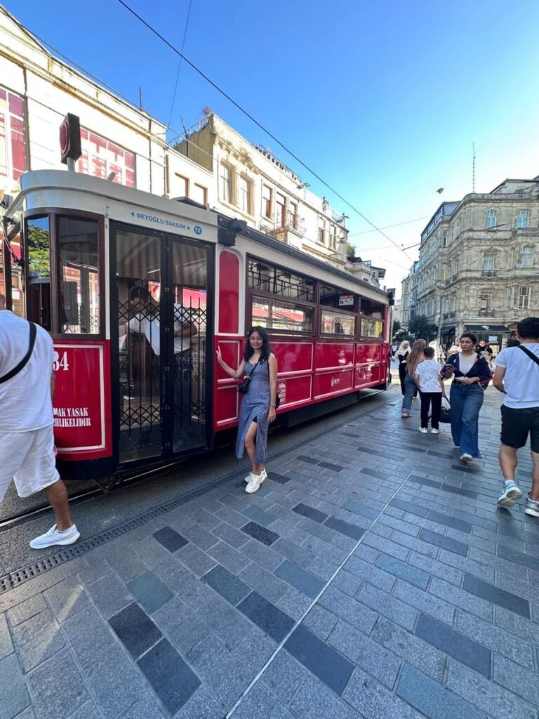 Sanju beside the red nostalgic tram on İstiklal Avenue