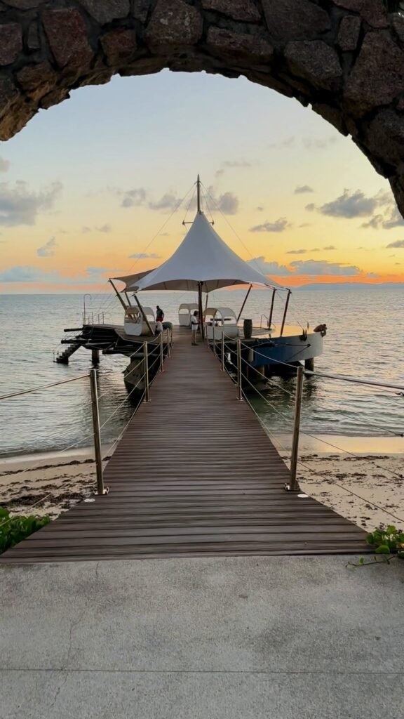 Stone arch and jetty at dusk on Praslin