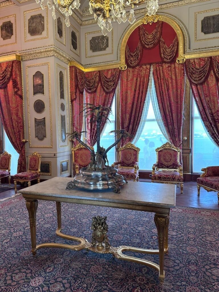 A room in Topkapı Palace with red curtains, gilded chairs and a silver centrepiece