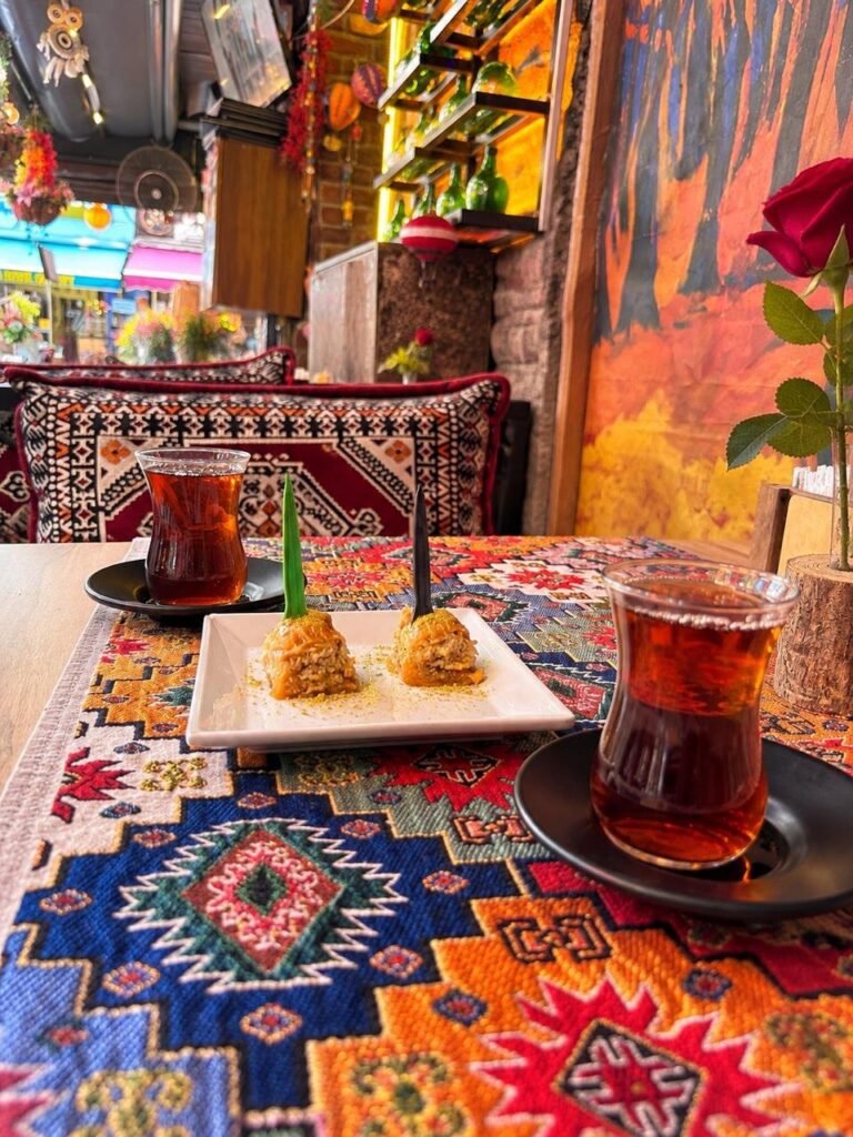 Two glasses of Turkish tea with baklava on a colourful table runner